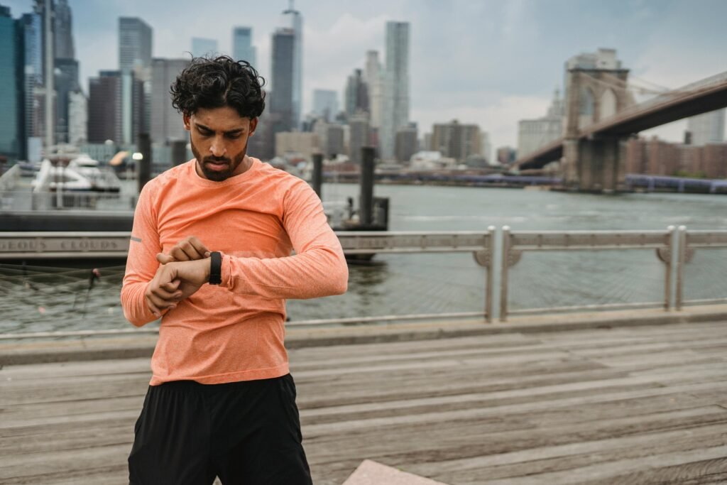 pexels photo 5037300 5037300 Adult man checks smartwatch while exercising by the Brooklyn Bridge, promoting healthy lifestyle.